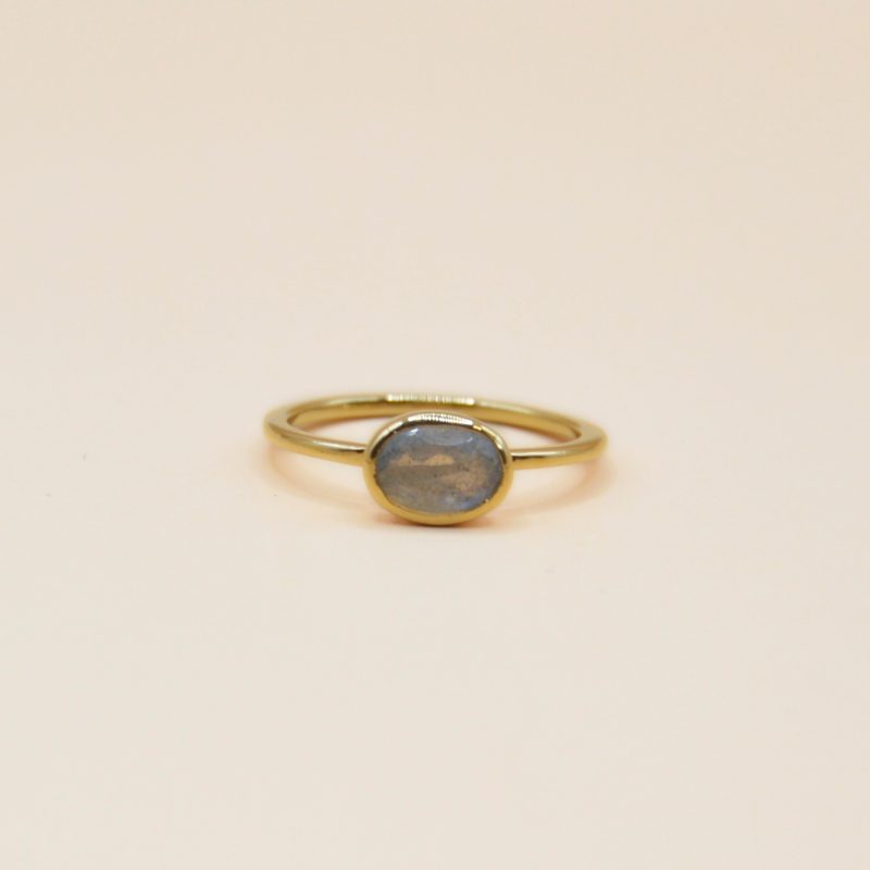 Notre bague Candice est le symbole même de l'élégance minimaliste. Confectionnée en plaqué or 3 microns, cette bague fine et délicate met en valeur la beauté naturelle de la pierre Labradorite ovale qui trône au centre. . Bijou seul, Crédit GEMITY
