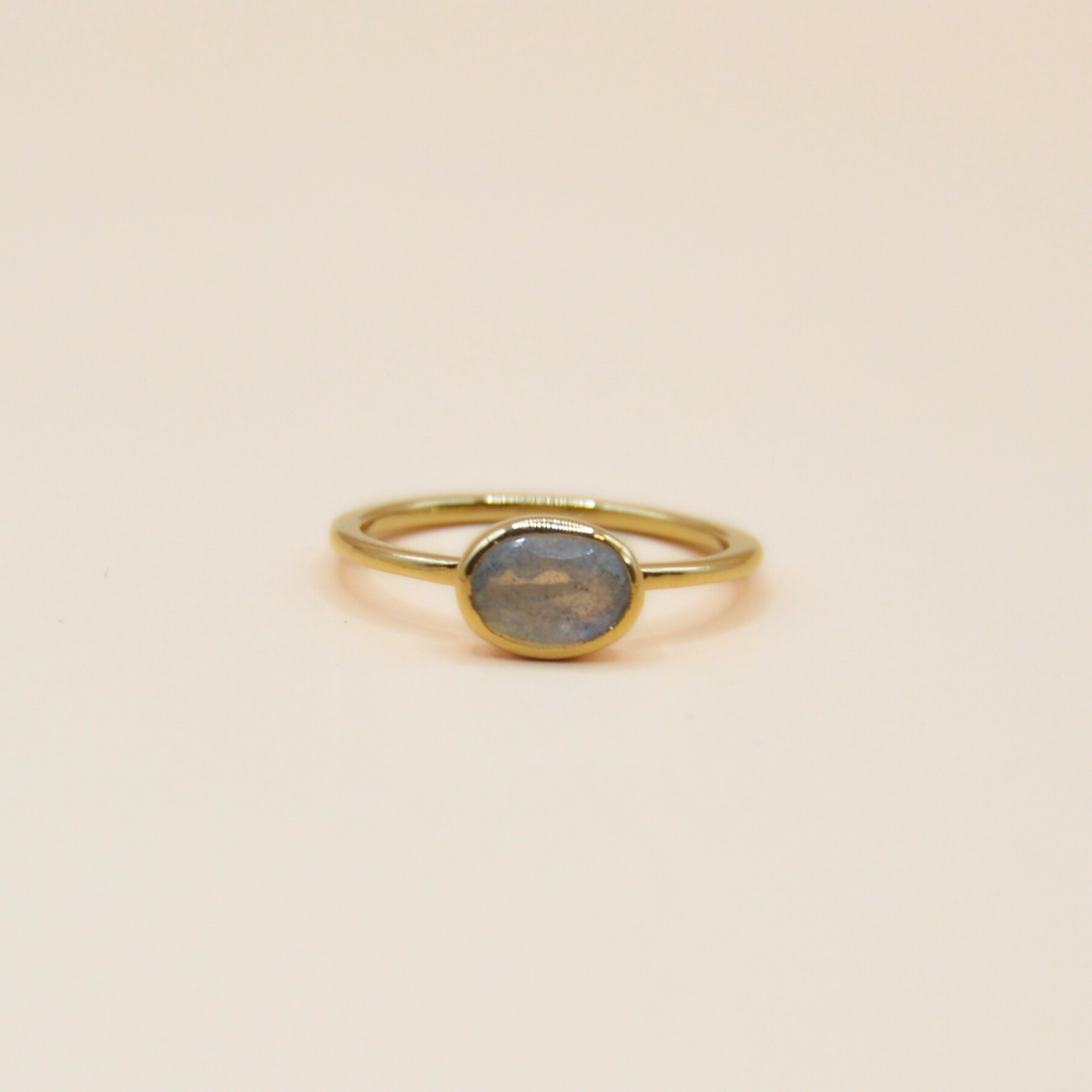 Notre bague Candice est le symbole même de l'élégance minimaliste. Confectionnée en plaqué or 3 microns, cette bague fine et délicate met en valeur la beauté naturelle de la pierre Labradorite ovale qui trône au centre. . Bijou seul, Crédit GEMITY