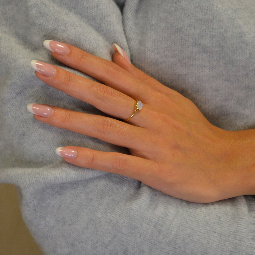 Notre bague Candice est le symbole même de l'élégance minimaliste. Confectionnée en plaqué or 3 microns, cette bague fine et délicate met en valeur la beauté naturelle de la pierre moonstone ovale qui trône au centre. Bijou porté, Crédit GEMITY.