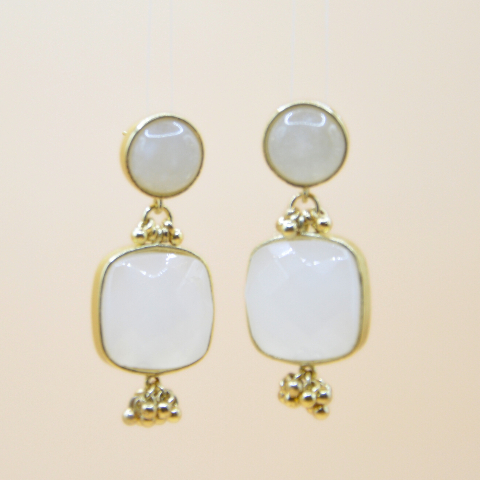 Boucles d'oreilles en laiton, dorées à l'or fin magnifiquement ornées d'agates blanches cubiques. Bijou seul, Crédit GEMITY