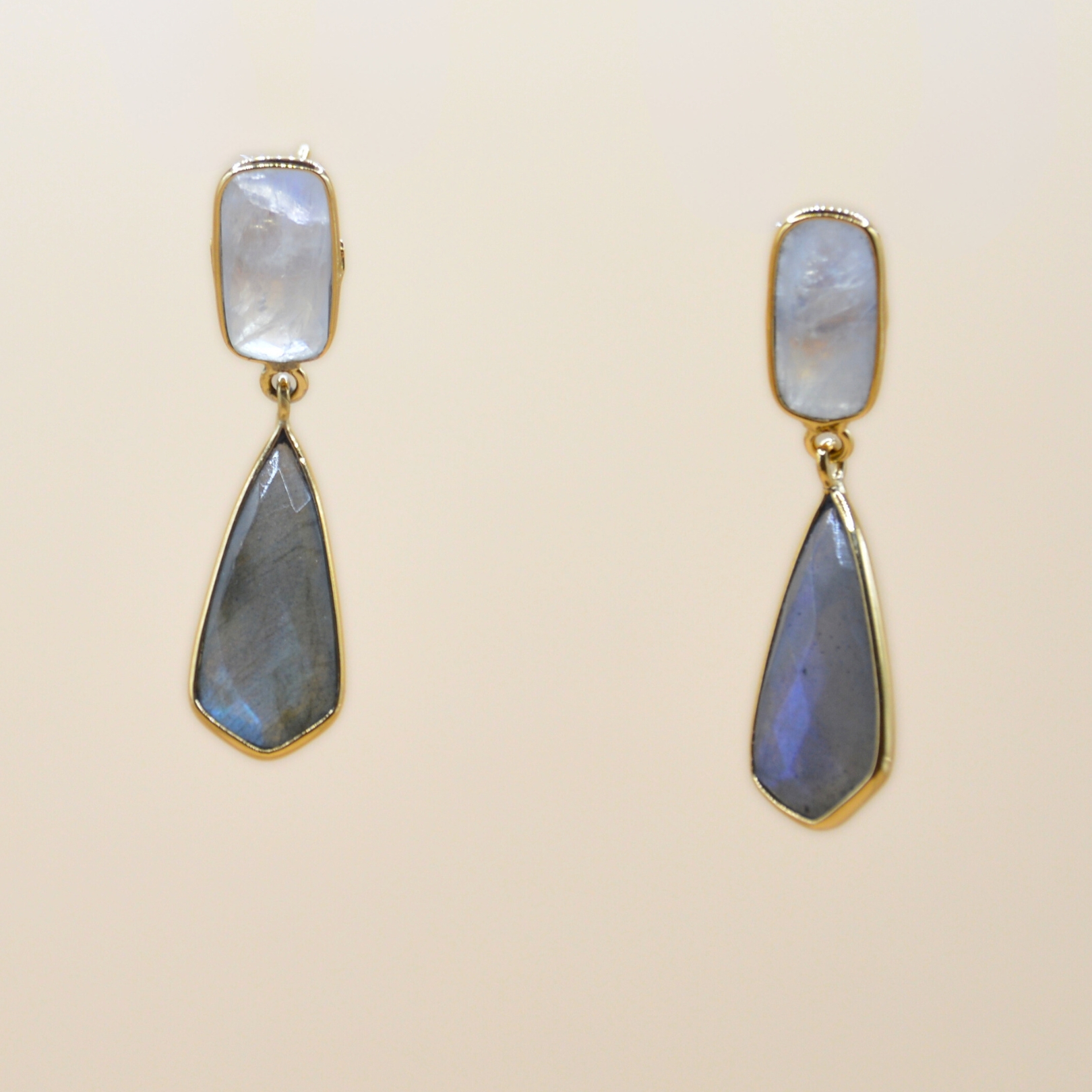 Magnifiques boucles d'oreilles articulées plaquées or 3 microns Terry. Ces créations raffinées mettent en valeur une pierre moonstone et une labradorite, offrant une touche de sophistication à chaque mouvement. Bijou seul, Crédit GEMITY