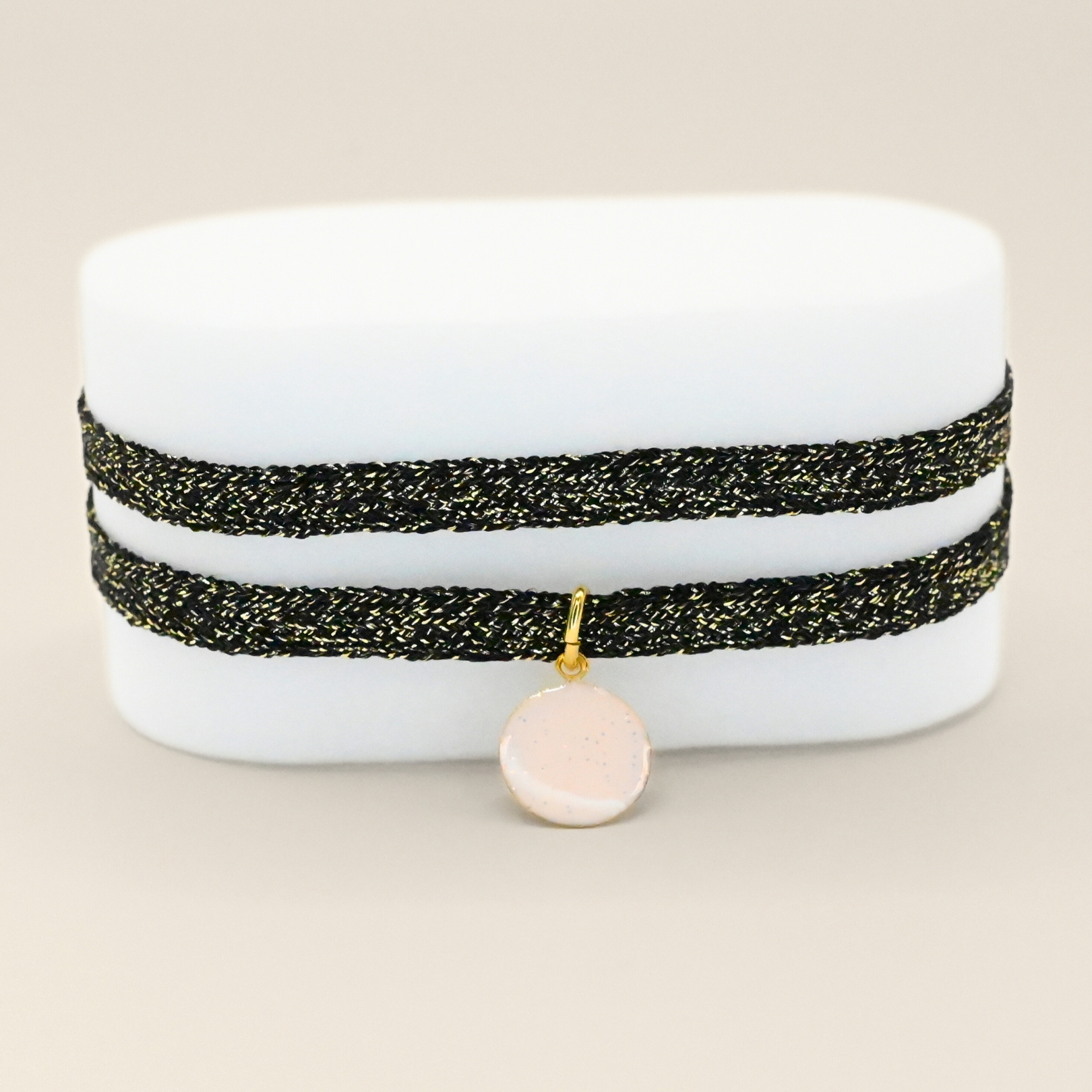 "Bracelet double tour ruban doré avec petite médaille d'indien plaqué or (3 microns) émaillée. Fermoir en plaqué or réglable . Bijou seul, Crédit GEMITY"