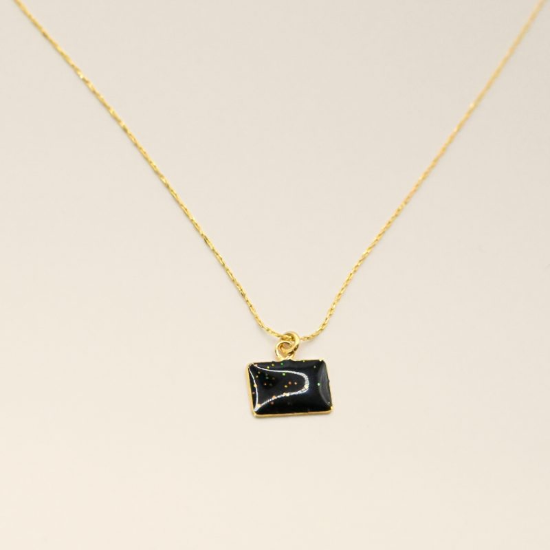 Collier plaqué or avec plaque extra-fine réversible, inscription LOVE d'un côté et émail noir pailleté de l'autre côté. Bijou seul, Crédit GEMITY