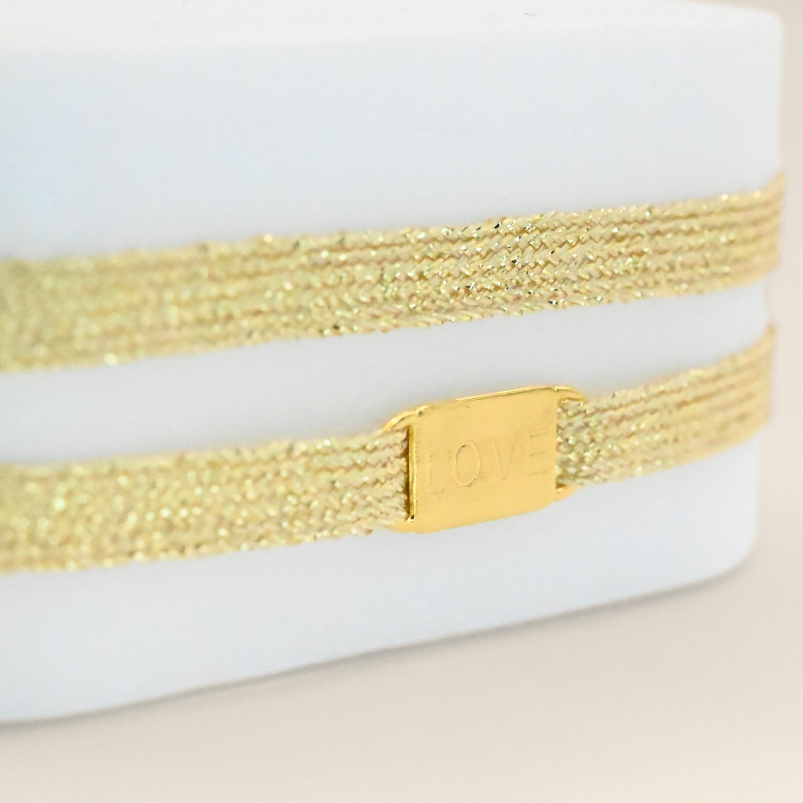 "Bracelet double tours avec une plaque LOVE en plaqué or (3 microns) fait main. Fermoir en plaqué or réglable . Bijou seul, Crédit GEMITY"
