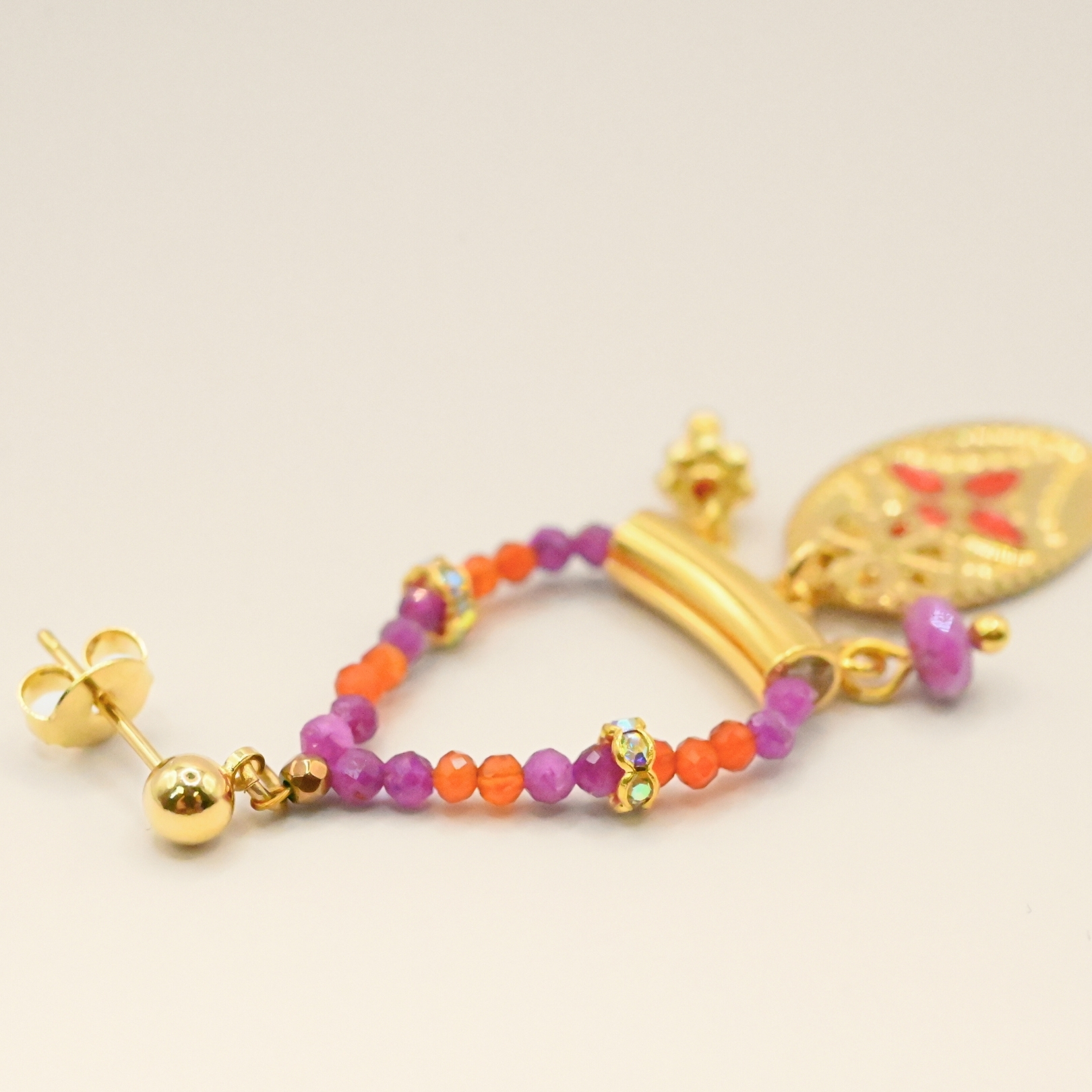 Ces boucles d’oreilles sont un véritable hommage à l’art indien. Chaque pièce est façonnée et émaillée à la main, mettant en valeur le savoir-faire traditionnel. Les pendentifs ovales évoquent des éléments floraux tels que le lotus, symbole porte-bonheur. Bijou seul, Crédit GEMITY