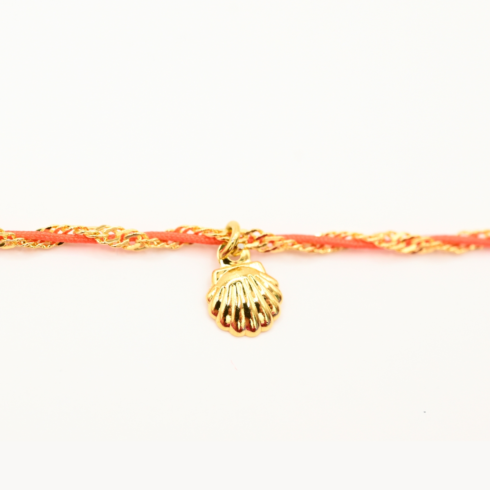 "L’élégance décontractée de la côte basque. Ce bracelet mêle fils de coton torsadé, touches dorées et couleurs vibrantes, pour une alliance parfaite entre raffinement et fraîcheur de l’océan. Orné d'un charm, il incarne une harmonie bohème et sophistiquée à porter au quotidien. Composition : Plaqué or et fils de coton torsadés. . Bijou seul, Crédit GEMITY"