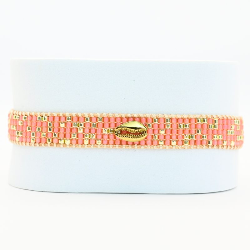 laissez-vous séduire par la beauté naturelle de cette petite manchette, composée de 5 rangs de perles corail soigneusement assemblées. L'ornement coquillage en son centre ajoute une touche marine et exotique, parfaite pour les amateurs de style bohème et élégant.. Bijou seul, Crédit GEMITY