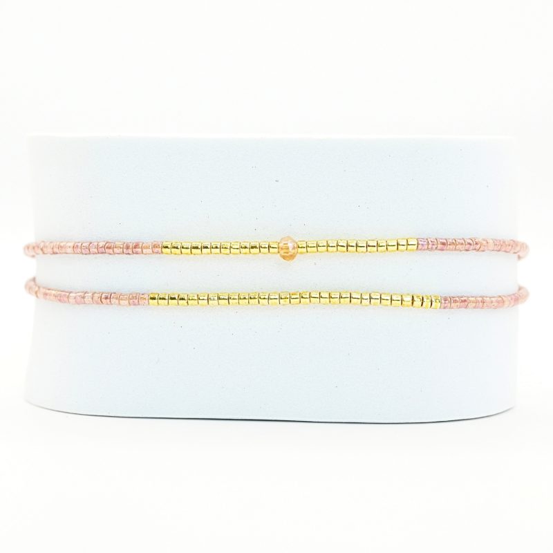 ce bracelet raffiné, composé de deux rangs, est l'accessoire parfait pour apporter de l'élégance à votre poignet. Le design associe des perles dorées et des perles nude, avec une disposition qui crée un équilibre parfait. . Bijou seul, Crédit GEMITY