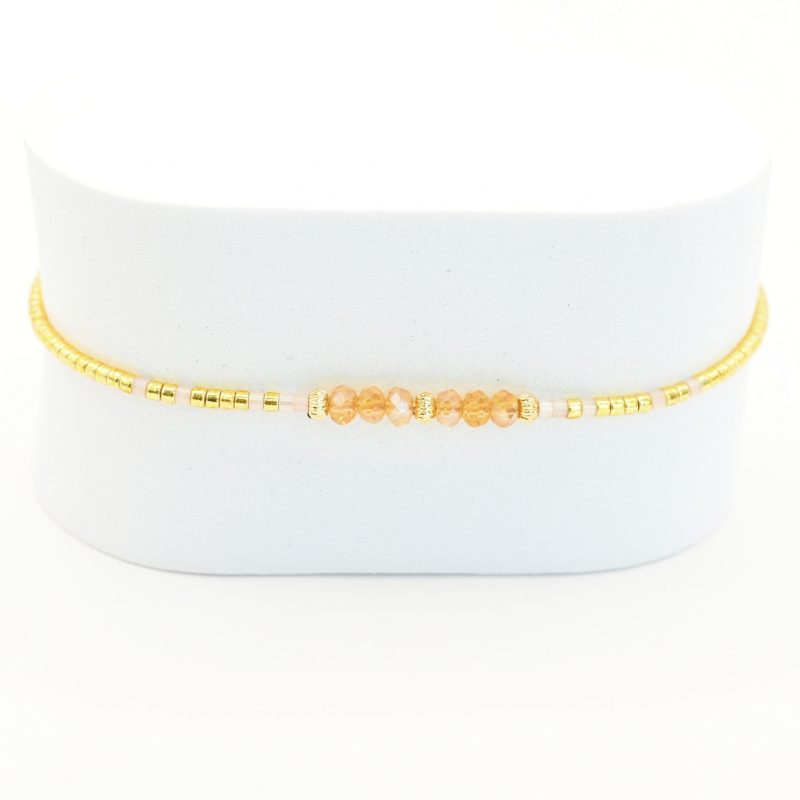un bracelet délicat et lumineux, parfait pour tous les jours ! Son cordon ajustable s’adapte à toutes les tailles, tandis que ses perles dorées et nude apportent une touche douce et élégante. . Bijou seul, Crédit GEMITY
