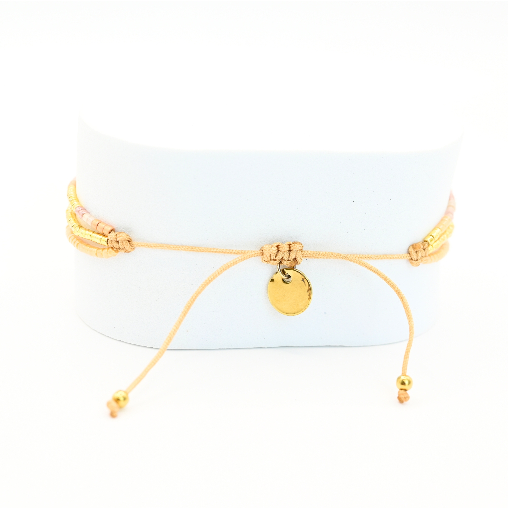 ce bracelet raffiné à 3 rangs combine des perles dorées et nude pour un look élégant et féminin. Le premier rang est orné de perles délicates, tandis que le second présente des perles plus grosses, créant un effet visuel dynamique. Le troisième rang se distingue par un charm étoile au centre, ajoutant une touche de magie et de sophistication. . Bijou seul, Crédit GEMITY