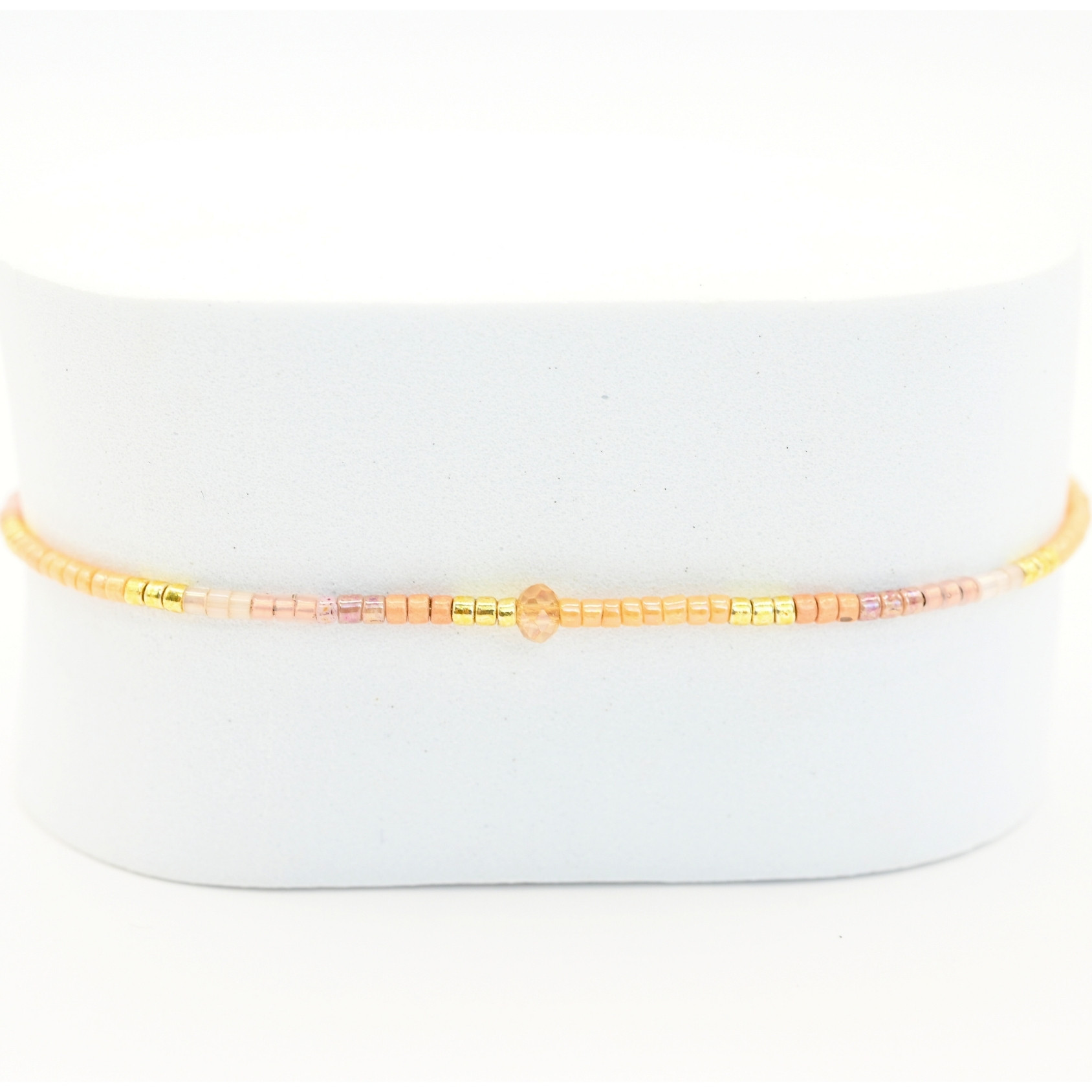 " ce bracelet délicat allie finesse et élégance avec son cordon ajustable et ses perles dorées et rose poudré. . Bijou seul, Crédit GEMITY"