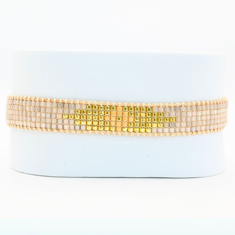 cette petite manchette à 5 rangs associe des perles nude avec un centre doré et rose pour un design à la fois doux et lumineux. . Bijou seul, Crédit GEMITY