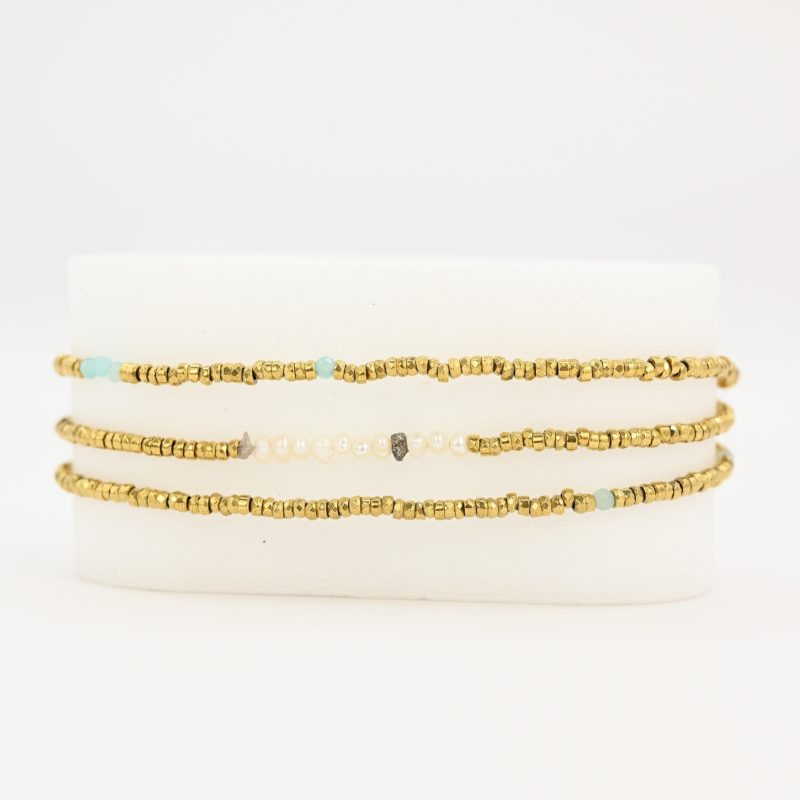 Ce bijou polyvalent se compose de petites perles dorées subtilement mises en valeur par quelques perles en nacre placées en son centre. . Bijou seul, Crédit GEMITY