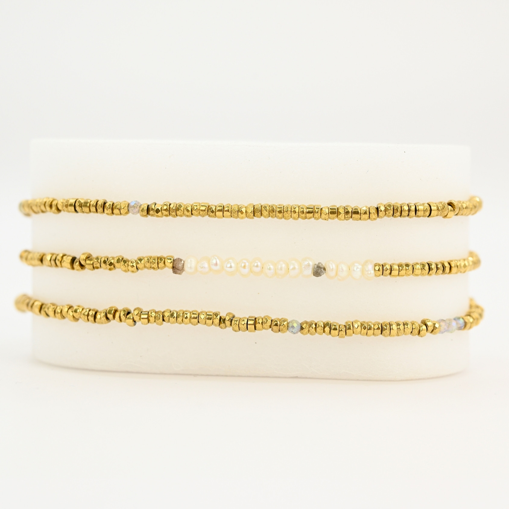 Ce bijou polyvalent se compose de petites perles dorées subtilement mises en valeur par quelques perles en nacre placées en son centre. . Bijou seul, Crédit GEMITY