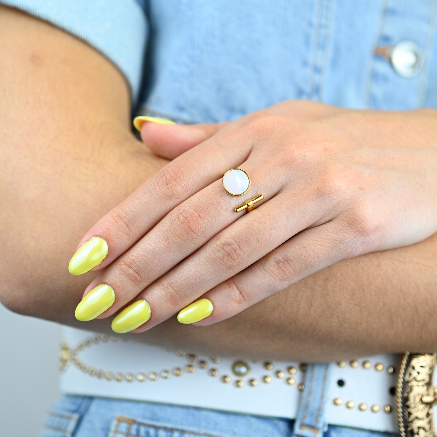 "La couleur blanche de la nacre naturelle s’associera avec tout votre dressing. Une nacre naturelle’ qui a été récupérée en Asie chez le producteur lors de nombreux voyages. Bague nacre RÉGLABLE Composition : métal doré à l'or fin 24 cts . Bijou porté, Crédit GEMITY."