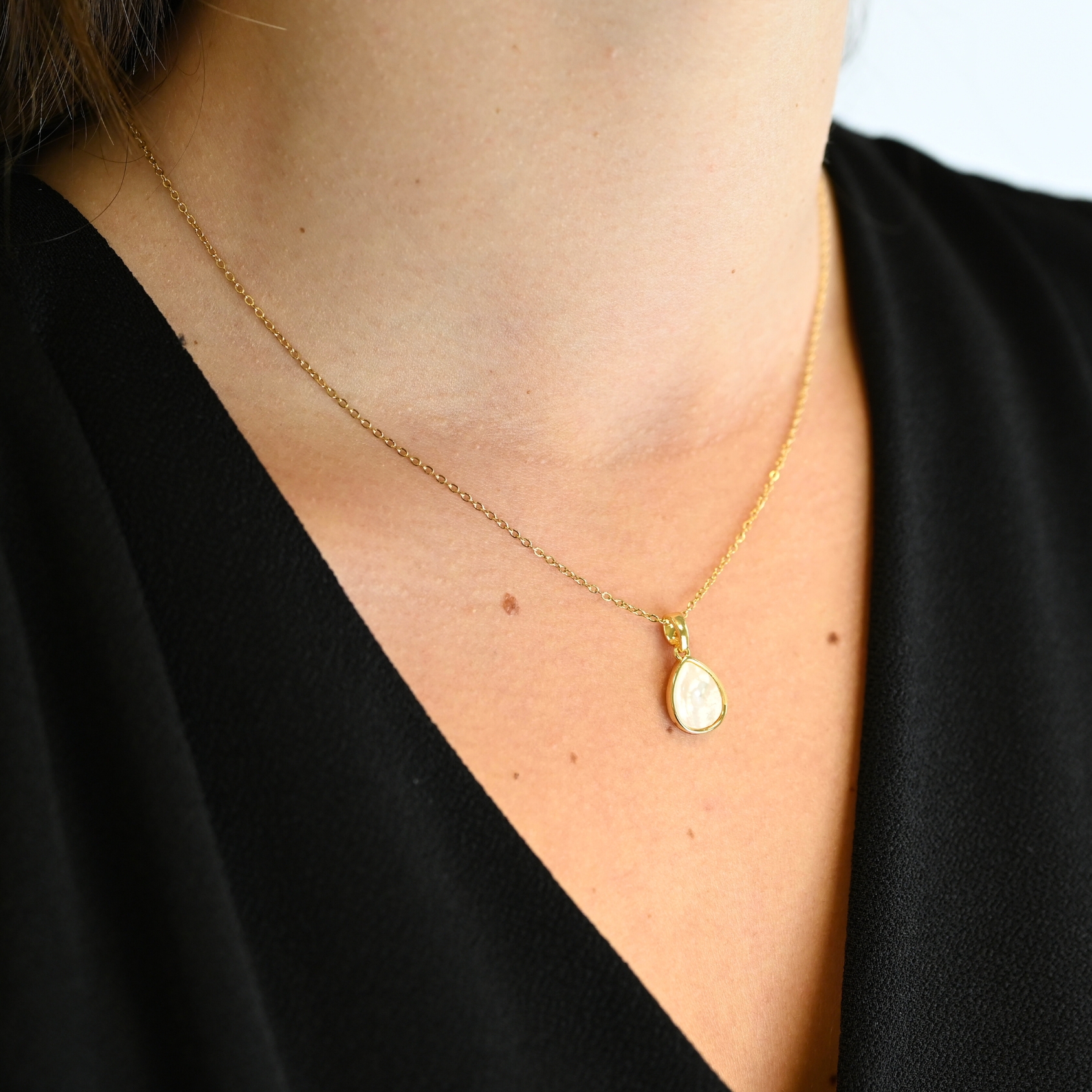 "Collier avec un nacre naturelle montée sur métal doré à l’or fin 24 carats avec un pendentif en forme de goutte d’eau de 1 cm de longueur. La longueur de la chaîne est de 40 cm + chaînette de rallonge. . Bijou porté, Crédit GEMITY."