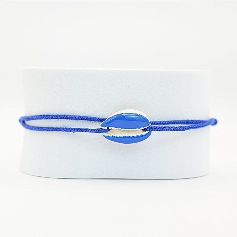 "Véritable cauri émaillé (longueur ≈ 1,5 cm) de la même couleur que le cordon. Lien cordon en coton ajustable, convient pour des poignets de 14 à 19 cm.. Bijou seul, Crédit GEMITY"