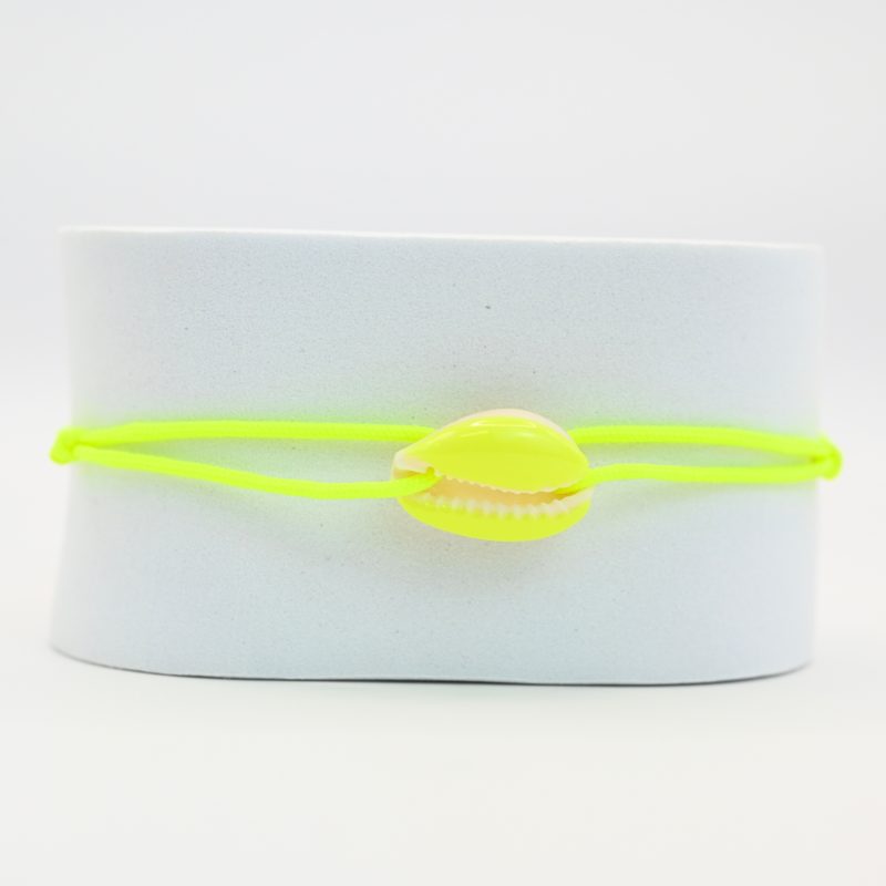"Véritable cauri émaillé (longueur ≈ 1,5 cm) de la même couleur que le cordon. Lien cordon en coton ajustable, convient pour des poignets de 14 à 19 cm.. Bijou seul, Crédit GEMITY"