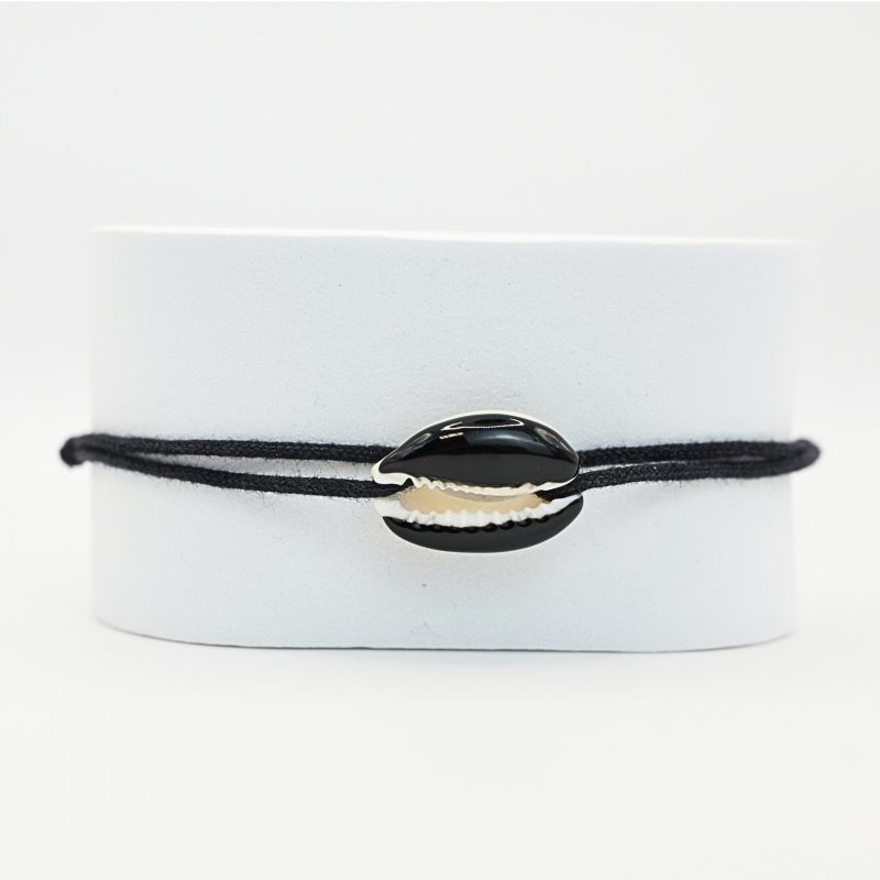 "Véritable cauri émaillé (longueur ≈ 1,5 cm) de la même couleur que le cordon. Lien cordon en coton ajustable, convient pour des poignets de 14 à 19 cm.. Bijou seul, Crédit GEMITY"