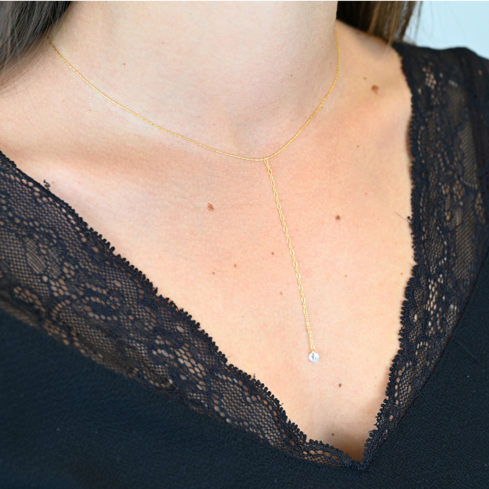 "Collier en plaqué or avec zirconium. Longueur du pendentif : 8 cm Taille de la chaîne : 39 cm (+5 cm de chaine de rappel) . Bijou porté, Crédit GEMITY."