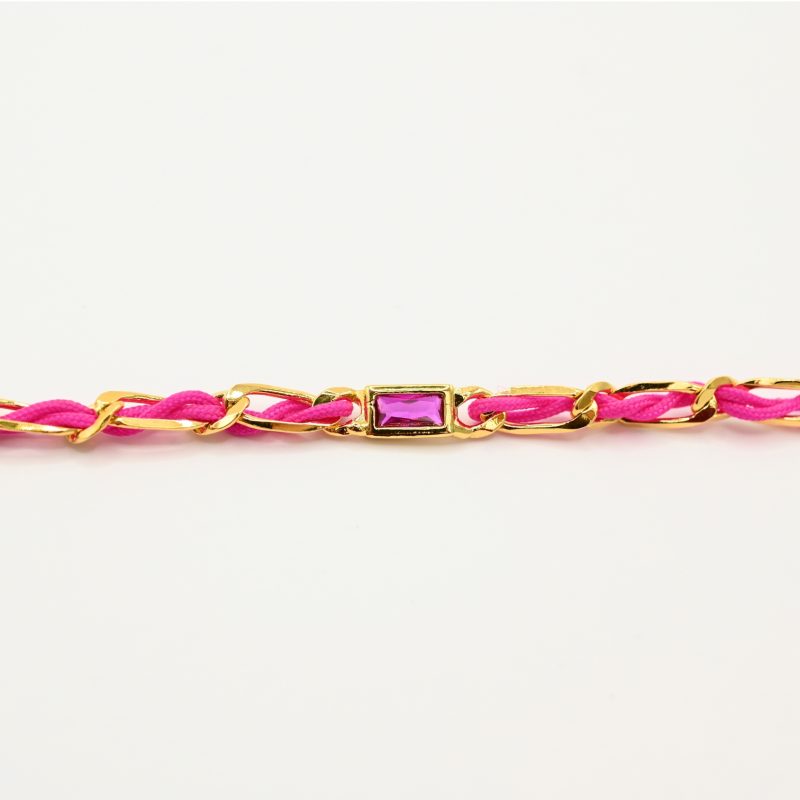 "Bracelet avec un cordon doré et un gemme transparent en son centre. Composition : 100% plaqué or. Contient 1 strass coloré transparent. . Bijou seul, Crédit GEMITY"