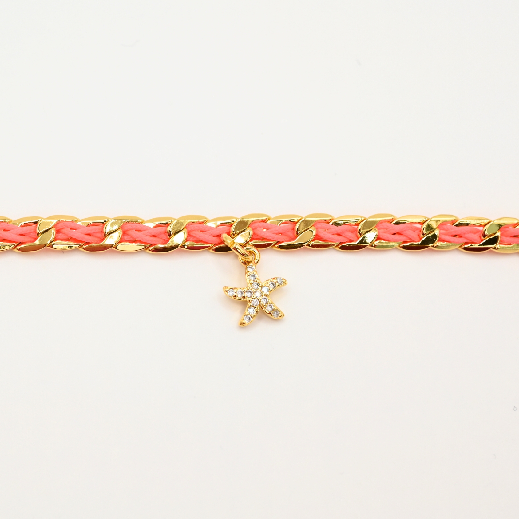 "1 pampille coeur strass Couleur tressage : rose poudré. Fermoir réglable. Matière : plaqué or et incrustation de fils de coton polyester tressés. Utilisation possible sous la douche ! . Bijou seul, Crédit GEMITY"